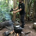 A man brewing coffee in the jungle