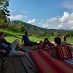 4 people relaxing on a wooden terrace in the Thai mountains